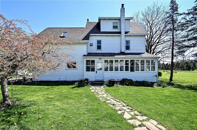 back of property with a yard and a sunroom