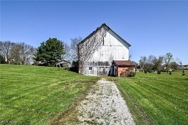 view of side of home with a yard and an outdoor structure