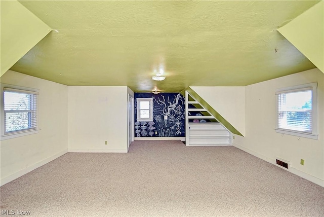 basement featuring a textured ceiling and carpet floors