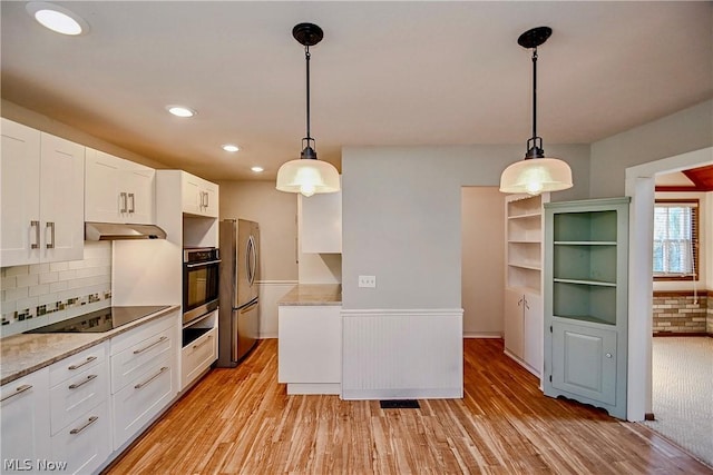 kitchen with white cabinets, appliances with stainless steel finishes, backsplash, and hanging light fixtures