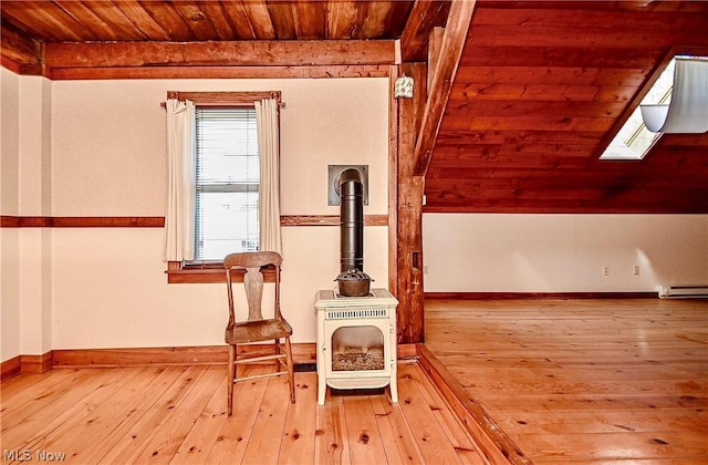 sitting room with a skylight, wood ceiling, a baseboard heating unit, and light wood-type flooring