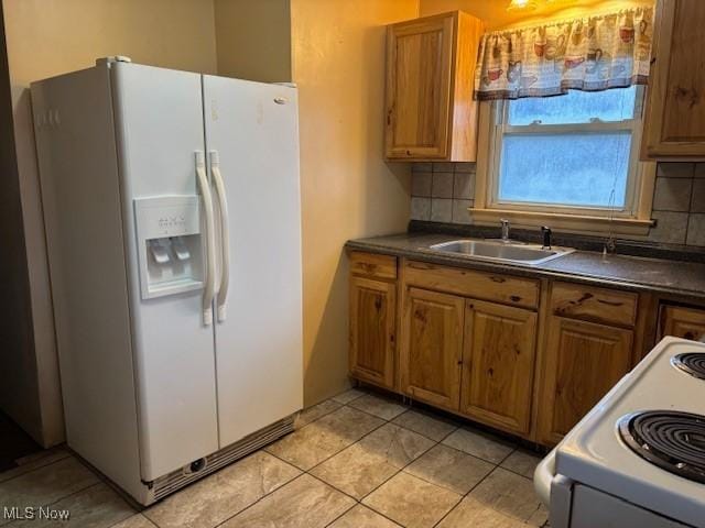 kitchen with decorative backsplash, white appliances, light tile patterned flooring, and sink