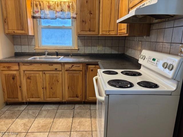 kitchen featuring tasteful backsplash, sink, light tile patterned flooring, and white electric stove