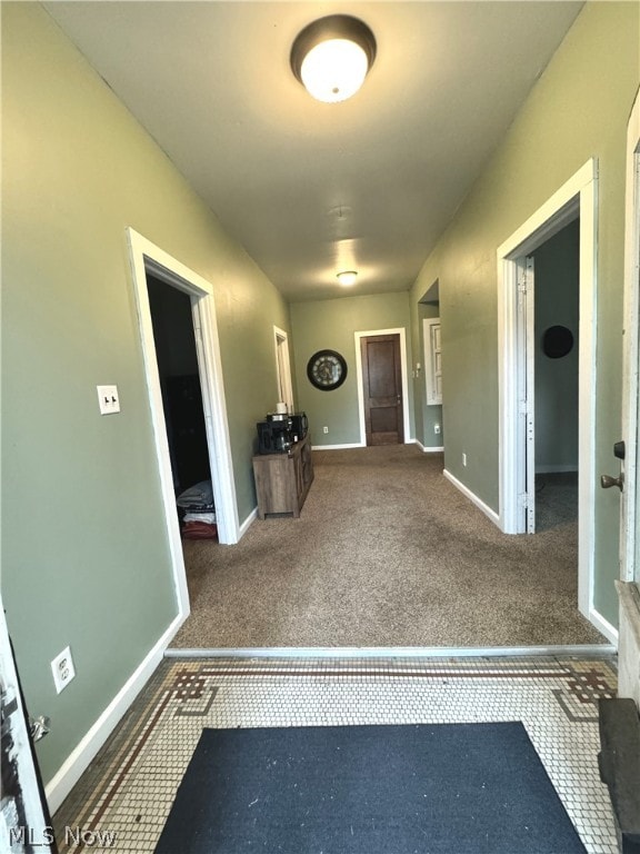 corridor featuring dark colored carpet