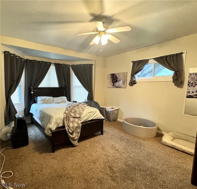 carpeted bedroom featuring multiple windows and ceiling fan