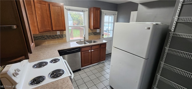 kitchen with light tile patterned floors, white appliances, backsplash, and sink