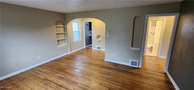 empty room featuring hardwood / wood-style flooring and a textured ceiling