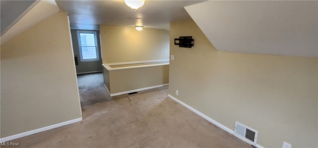 additional living space featuring light carpet and vaulted ceiling