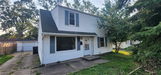 view of front of home featuring a front lawn, an outbuilding, and a garage