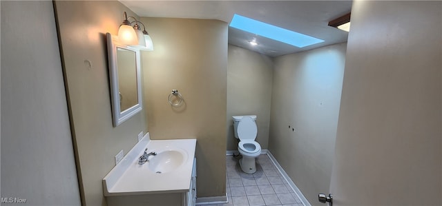 bathroom with vanity, toilet, tile patterned floors, and a skylight