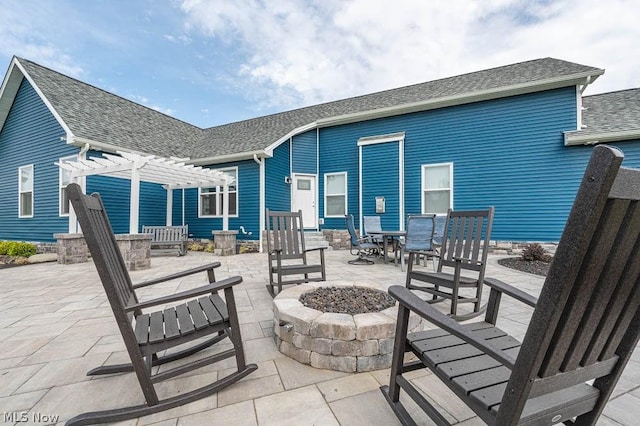 rear view of property featuring a pergola, a patio area, and a fire pit