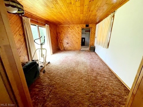 unfurnished living room with carpet floors and wood ceiling