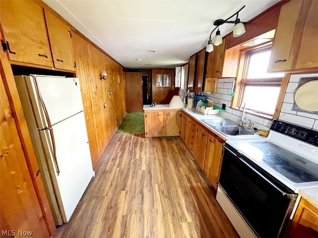 kitchen featuring white refrigerator, light hardwood / wood-style flooring, backsplash, sink, and electric stove