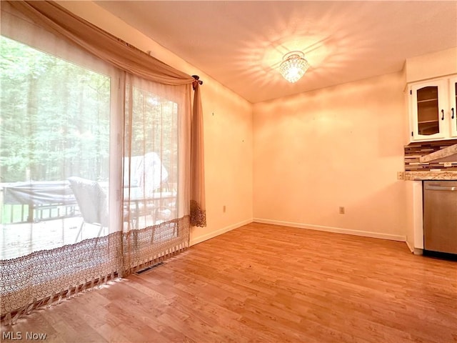 interior space featuring light wood-type flooring, baseboards, and visible vents