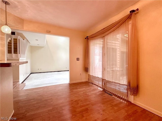 interior space with stairs, wood finished floors, and baseboards