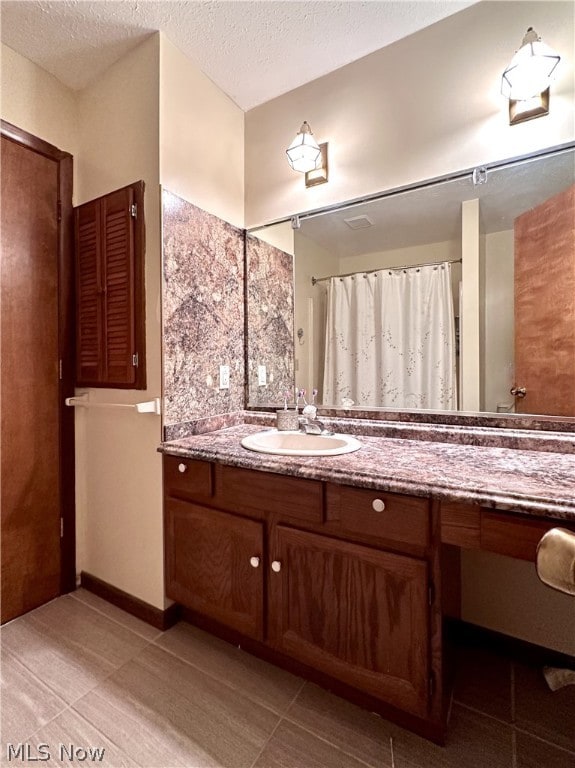 bathroom featuring vanity, a textured ceiling, and tile floors