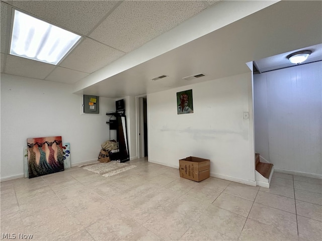 interior space with light tile floors and a drop ceiling