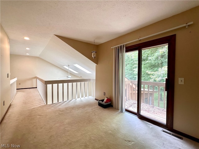 interior space featuring ceiling fan, lofted ceiling, a wealth of natural light, and light carpet