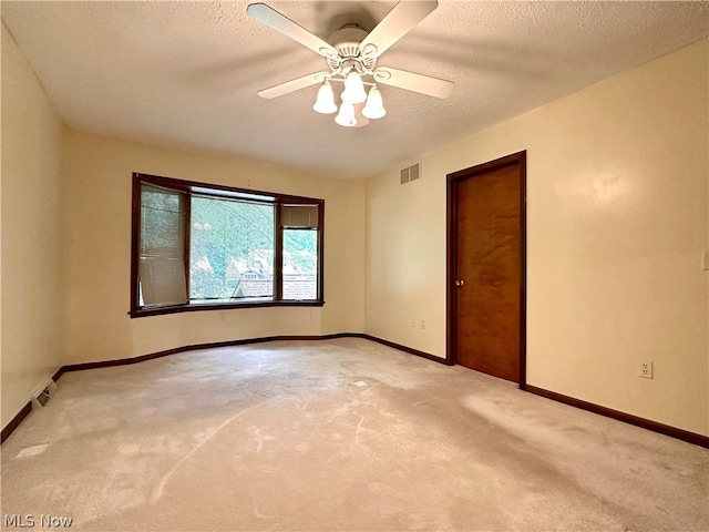 unfurnished room featuring ceiling fan, carpet floors, and a textured ceiling