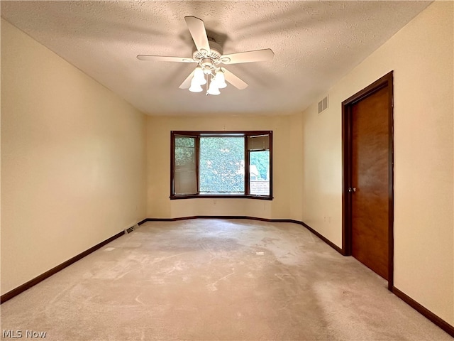 unfurnished room featuring carpet, ceiling fan, and a textured ceiling