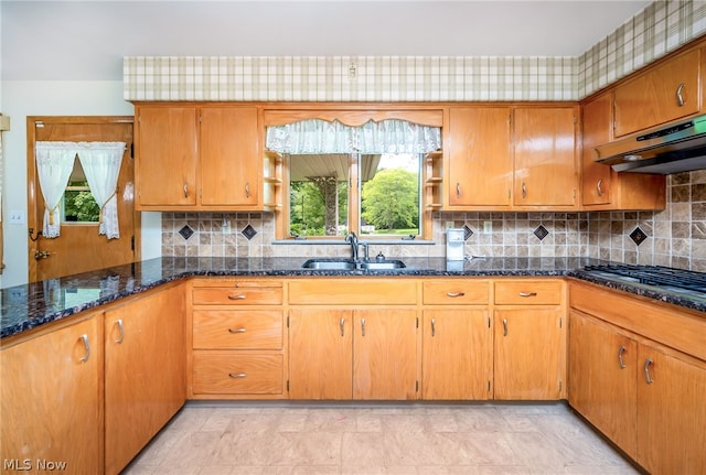 kitchen with ventilation hood, sink, decorative backsplash, dark stone countertops, and stainless steel gas cooktop