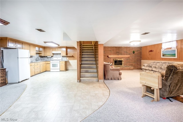 living room featuring sink, brick wall, and a brick fireplace