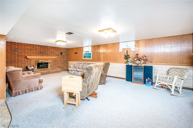 carpeted living room featuring a fireplace, wood walls, and brick wall