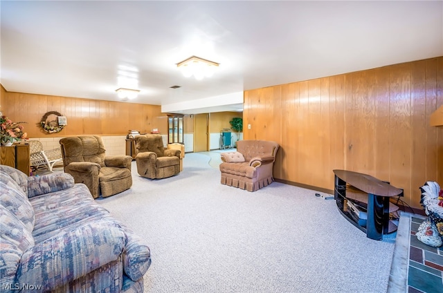 carpeted living room featuring wood walls