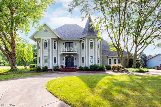 view of front of property with a front lawn and a balcony