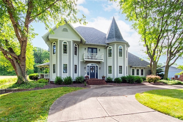 victorian home with a front lawn and a balcony