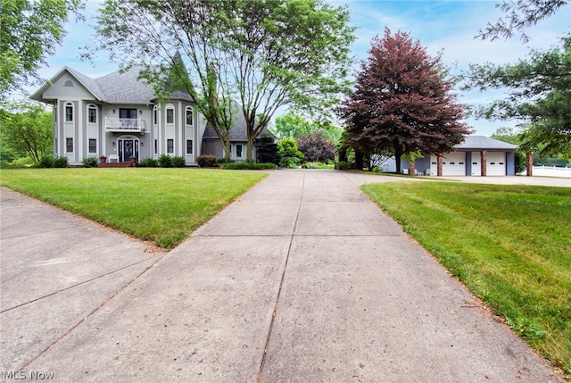 view of front of house featuring a front lawn, a garage, and a balcony