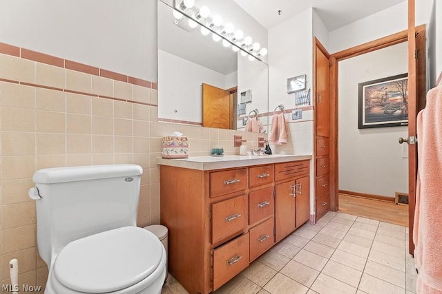 bathroom with visible vents, tile walls, toilet, and tile patterned floors