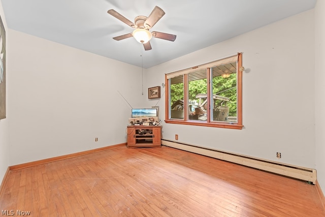 spare room with baseboard heating, ceiling fan, and light wood-type flooring