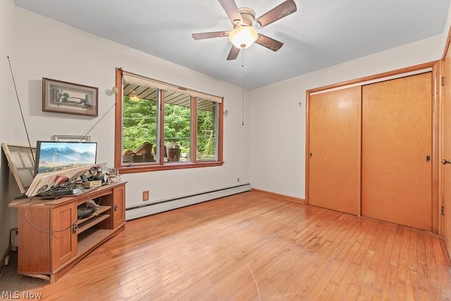 interior space with ceiling fan, light wood finished floors, a baseboard radiator, and baseboards