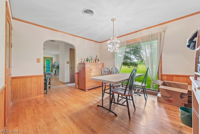 dining room with a chandelier, light hardwood / wood-style floors, and ornamental molding