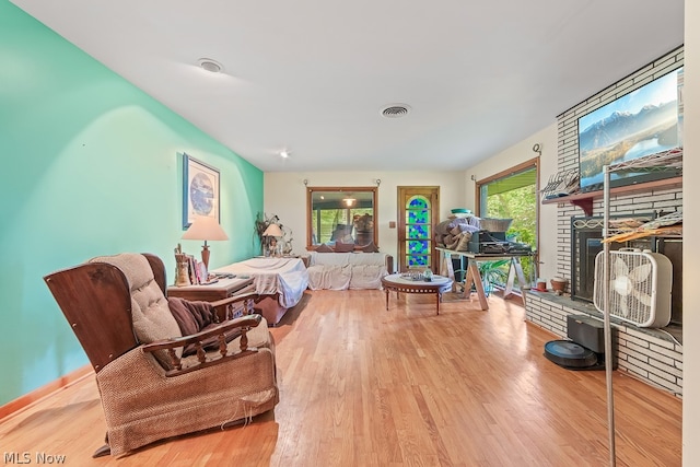 living room with a large fireplace and light wood-type flooring