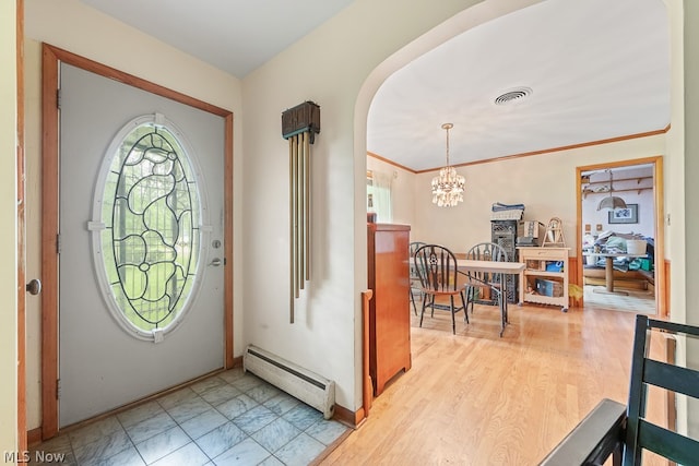 tiled entrance foyer featuring a chandelier, baseboard heating, and crown molding