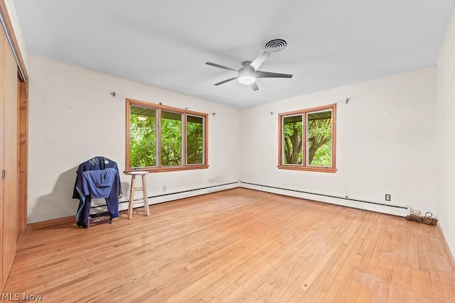 empty room featuring ceiling fan, light wood-type flooring, plenty of natural light, and a baseboard radiator