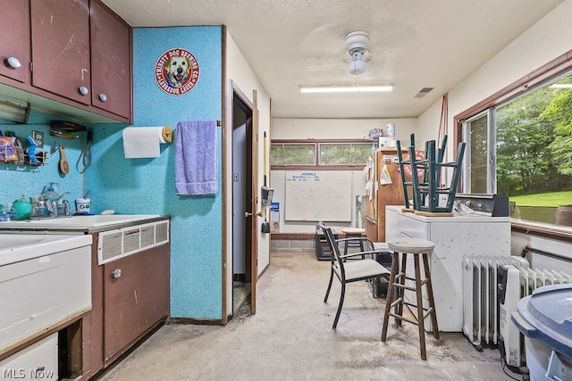 kitchen with radiator, plenty of natural light, and a textured ceiling