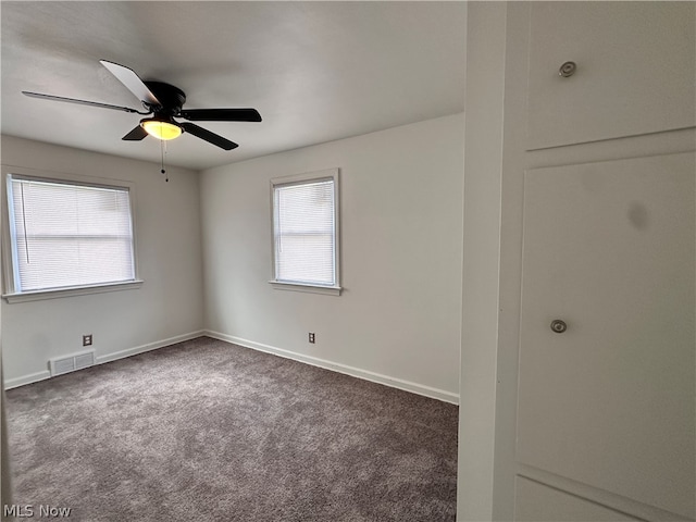 carpeted spare room with ceiling fan and plenty of natural light