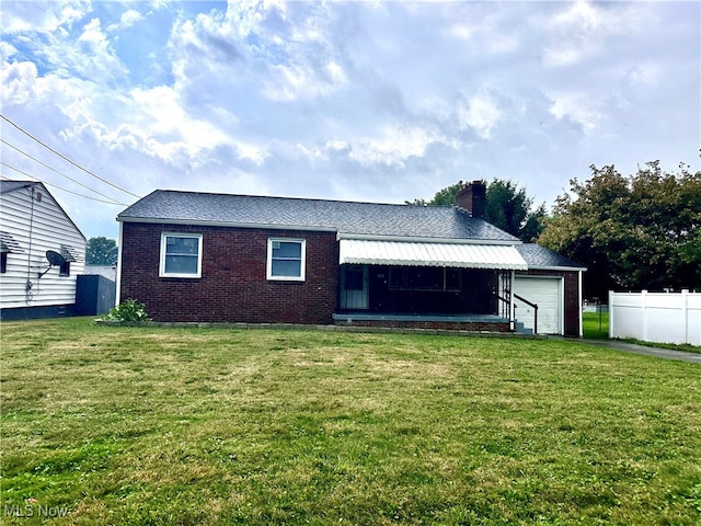 rear view of property featuring a lawn