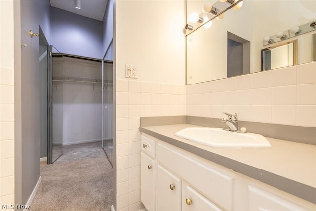 bathroom featuring vanity and tile walls