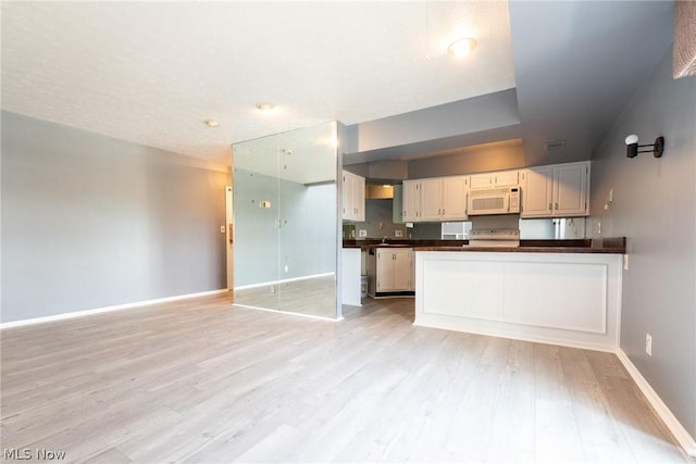 kitchen featuring white cabinets, stove, and light hardwood / wood-style flooring