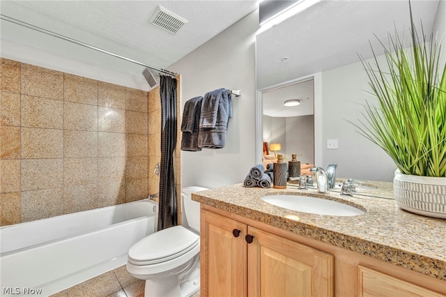 full bathroom with vanity, a textured ceiling, shower / bath combo with shower curtain, tile patterned flooring, and toilet