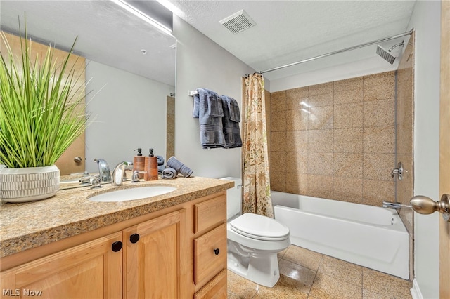 full bathroom with a textured ceiling, vanity, shower / bath combo with shower curtain, tile patterned flooring, and toilet