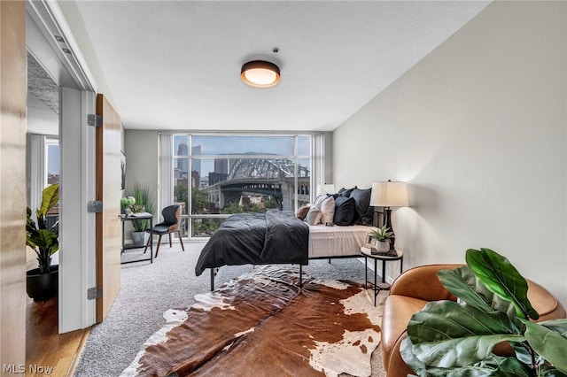 bedroom featuring expansive windows and hardwood / wood-style flooring