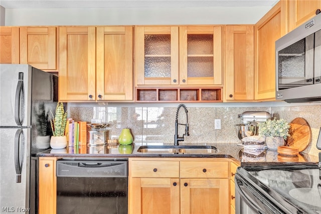 kitchen with decorative backsplash, sink, dark stone counters, and black appliances