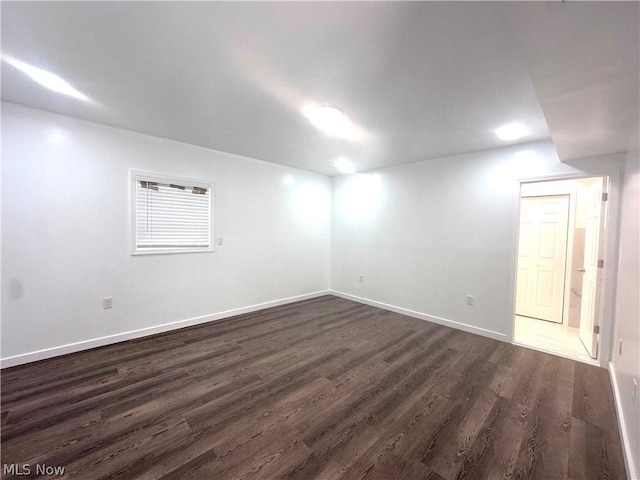 unfurnished room with dark wood-type flooring