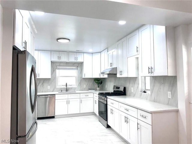 kitchen featuring white cabinets, sink, stainless steel appliances, and tasteful backsplash