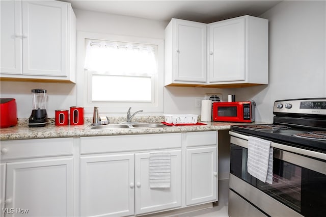 kitchen featuring white cabinets, stainless steel electric range oven, and sink